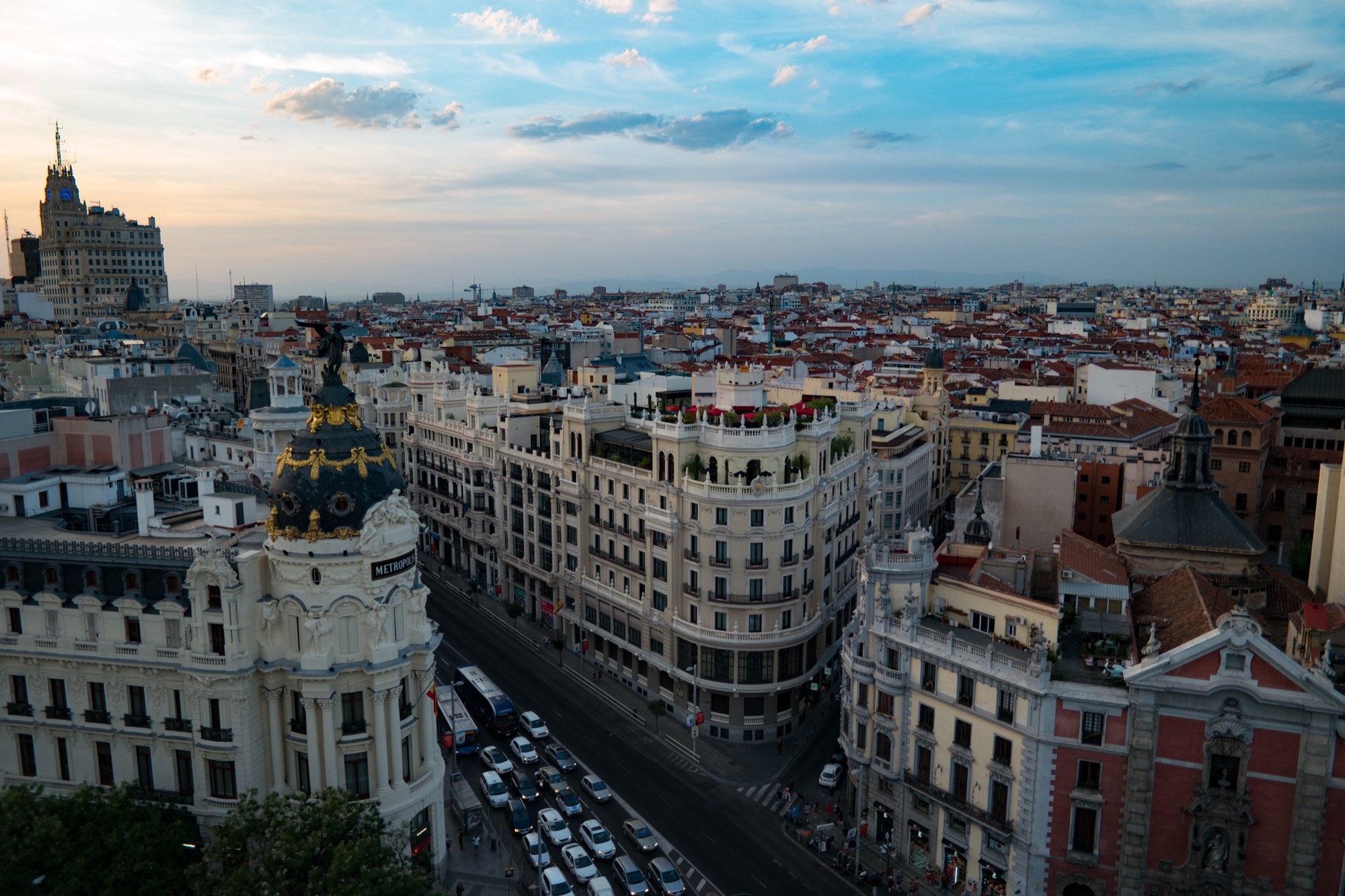 Madrid's Gran Vía at dusk, with the Metrópolis and Telefónica buildings.